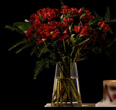 Festive red chrysanthemum and alstroemeria bouquet in glass vase. Shop now