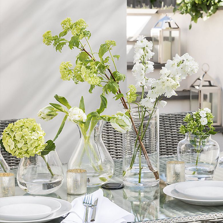 Vases of fresh flowers on an outdoor dining table