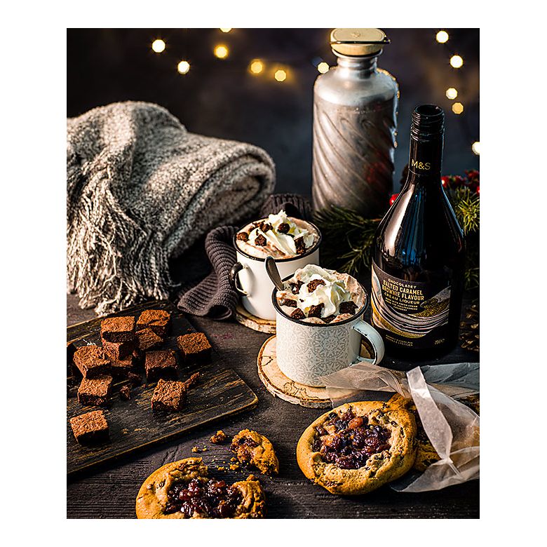 Salted caramel brownie liqueur hot chocolate topped with cream and brownie bites and served with mince pie cookies