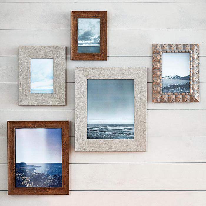 Picture frames with travel photos on a wall