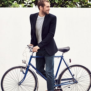Man wearing jeans and blazer with bicycle