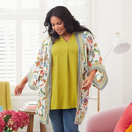 Model wearing a floral kimono, yellow top and blue jeans from the Curve collection