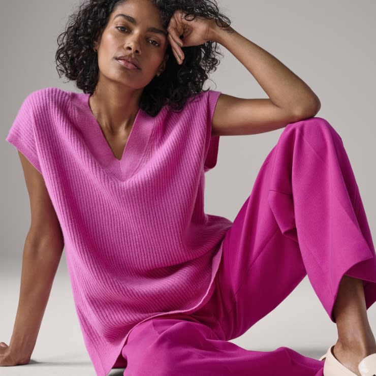 Woman wearing a pink cashmere vest. Shop cashmere