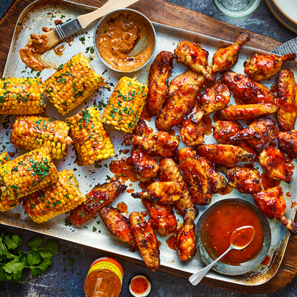 Tom Kerridge's smoky buffalo chicken wings on a tray with corn on the cob