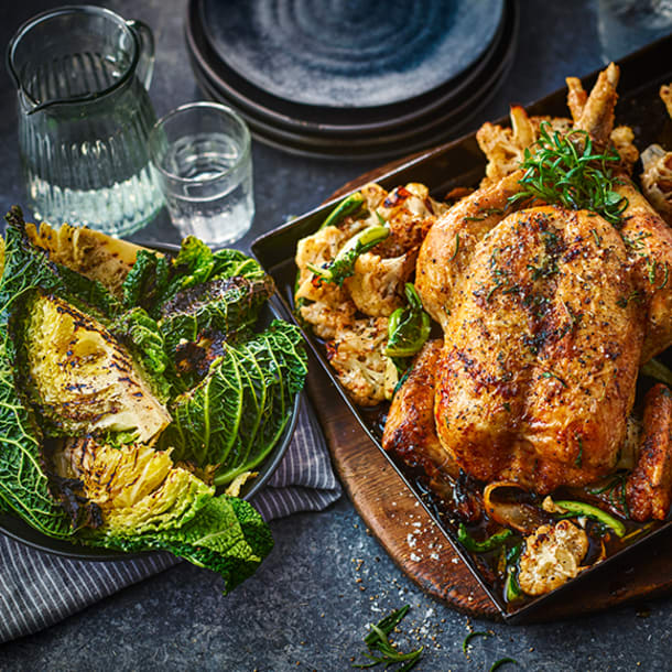 	
Whole herby roast chicken sat on cauliflower florets with charred cabbage in bowl