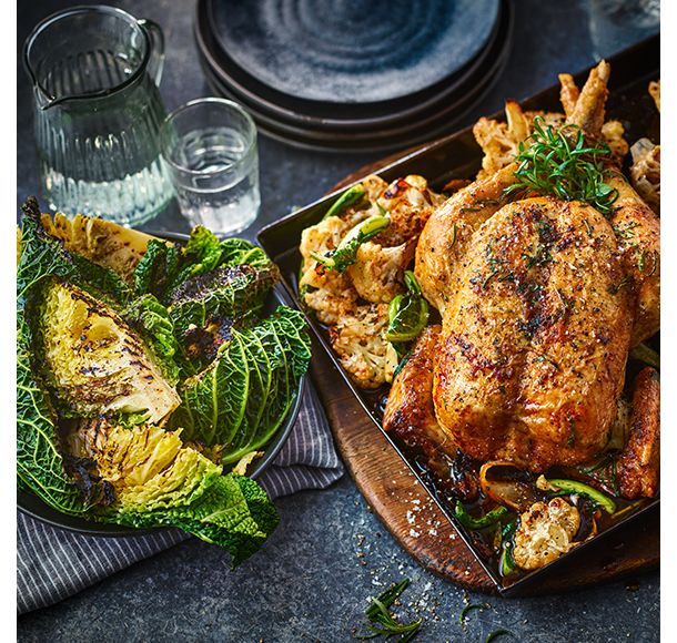 	
Whole herby roast chicken sat on cauliflower florets with charred cabbage in bowl