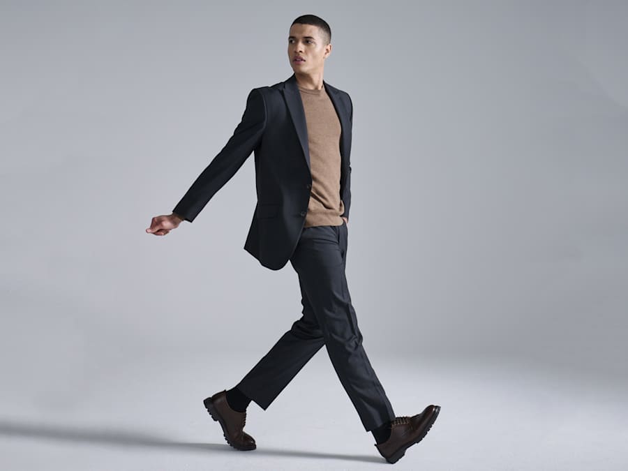 Man wearing navy suit and camel jumper. Read the feature