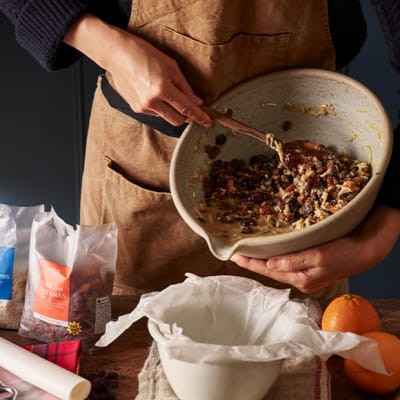 A home cook mixing a bowl of Christmas pudding ingredients