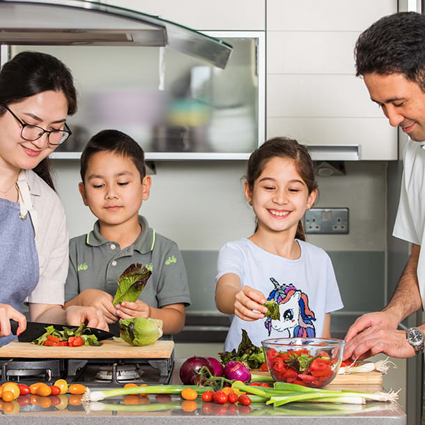 A family of four cooking together