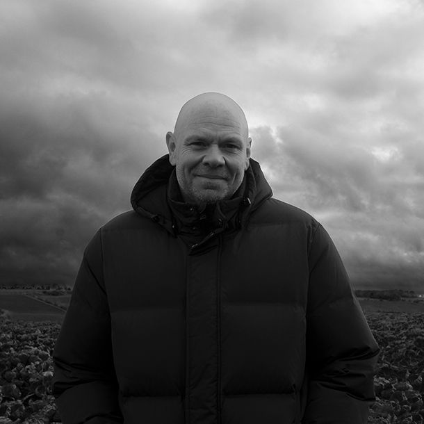 A black and white picture of chef Tom Kerridge in a field smiling