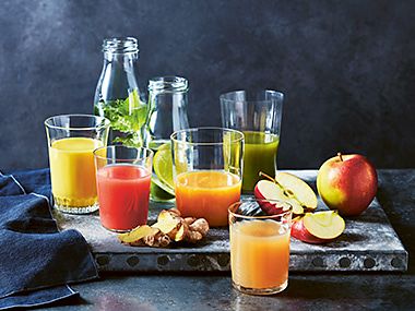 Table with several glasses of fruit juice on
