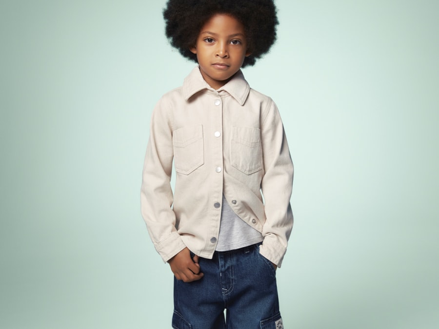 Girl wearing blue jeans, white T-shirt and pink trainers