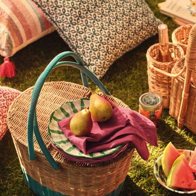 Picnic setting featuring picnic hamper and patterned cushions. Shop garden accessories