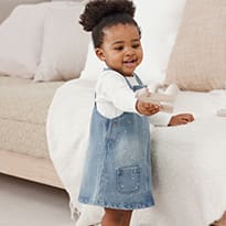 Baby girl wearing M&S denim pinny