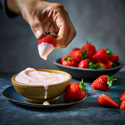 Strawberries dipped in pink gin cream