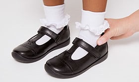 Adult checking the top-line edge of child's shoe