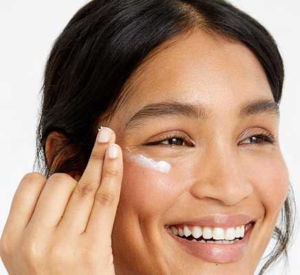 Woman applying moisturiser