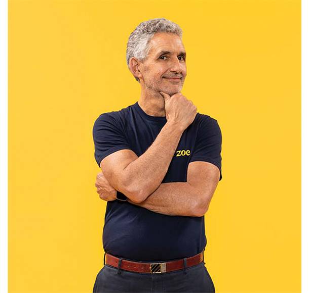 Professor Tim Spector smiling on yellow background