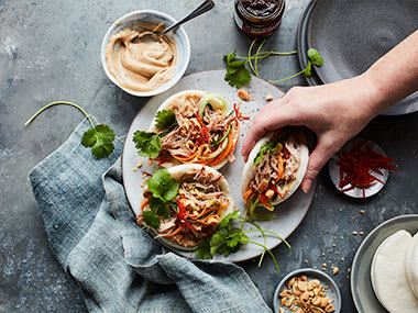 Bao buns with slow-cooked pork, pickled vegetables, chilli, peanuts and umami mayo