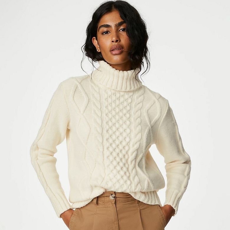 Sienna Miller wearing a cream cable-knit jumper. Shop women’s knitwear