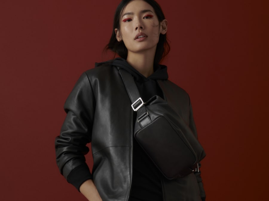 Woman wearing black faux-leather jacket and skirt. See the autumn trend guide