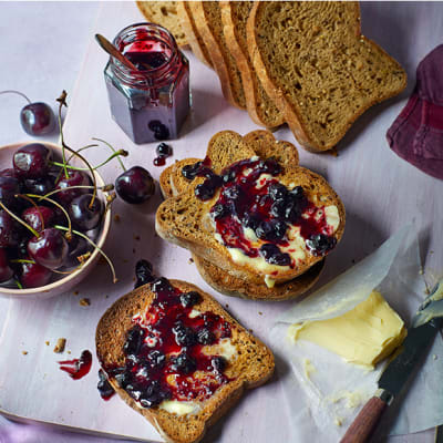 Made Without Wheat seeded loaf slices spread with butter and cherry jam