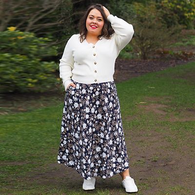 Woman wearing cream cardigan and printed floral skirt