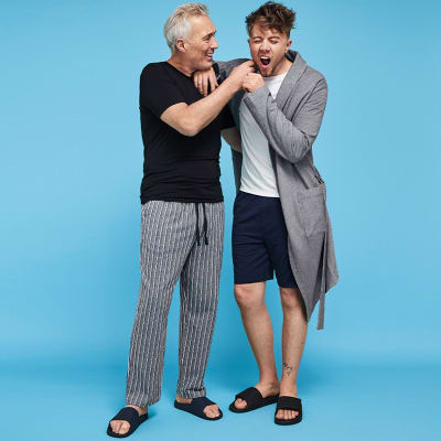 Martin Kemp wearing a T-shirt and pyjama bottoms with Roman Kemp wearing a grey robe, T-shirt and shorts