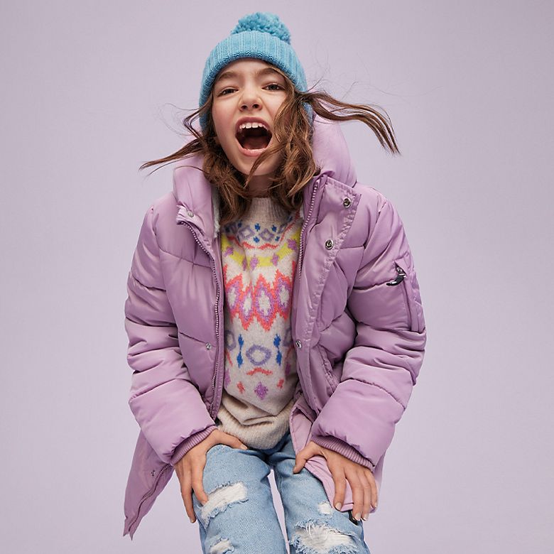 Girl wearing lilac puffer coat, pastel Fair Isle jumper and light-wash jeans 
