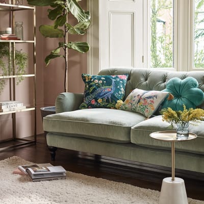 Living room with green sofa and a selection of colourful cushions