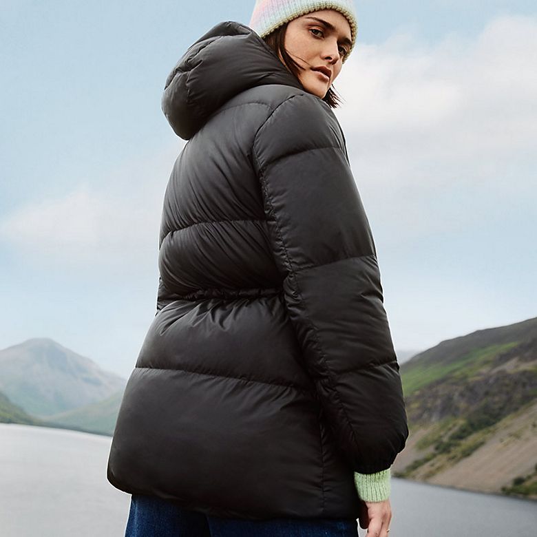 Woman wearing black hooded puffer jacket. Shop women’s puffer jackets