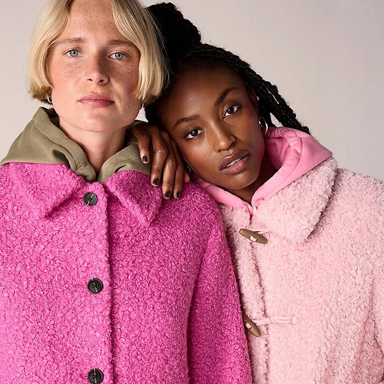 Two women wearing pink winter coats. Shop women’s coats 