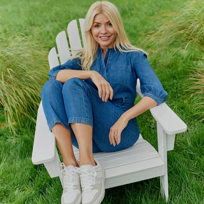 Holly Willoughby wearing blue denim jumpsuit and white trainers. Shop women’s new in