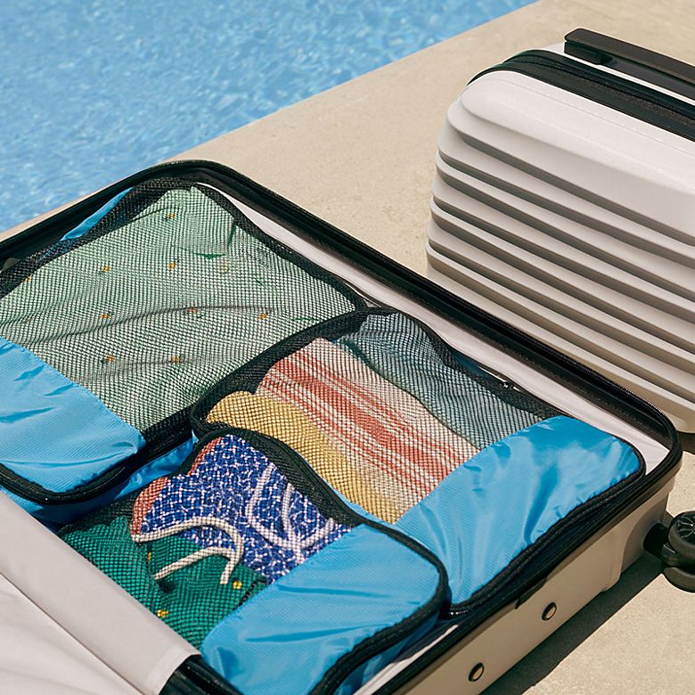 A packed suitcase by a swimming pool. Shop luggage