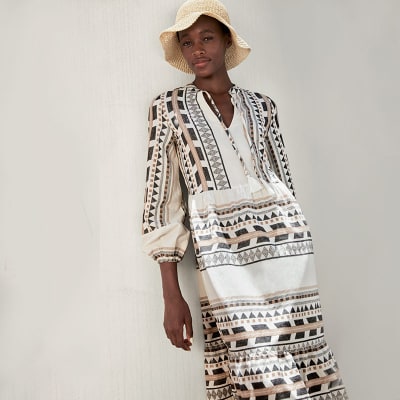 Woman wearing Ikat-print cotton beach kaftan dress. Visit the women’s holiday shop