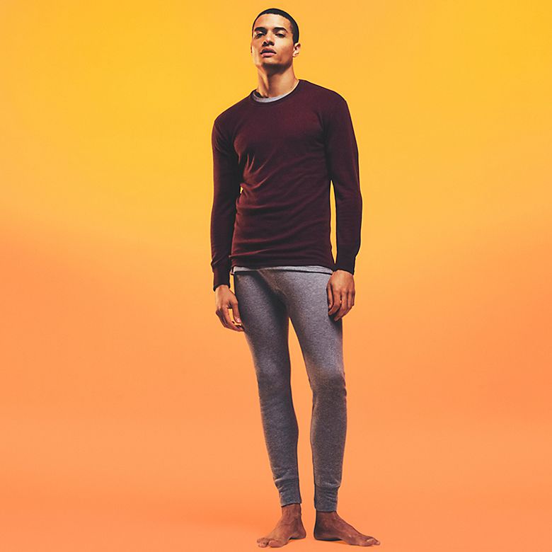Man wearing burgundy long-sleeved thermal top and grey thermal long johns. Shop men’s thermal long johns 