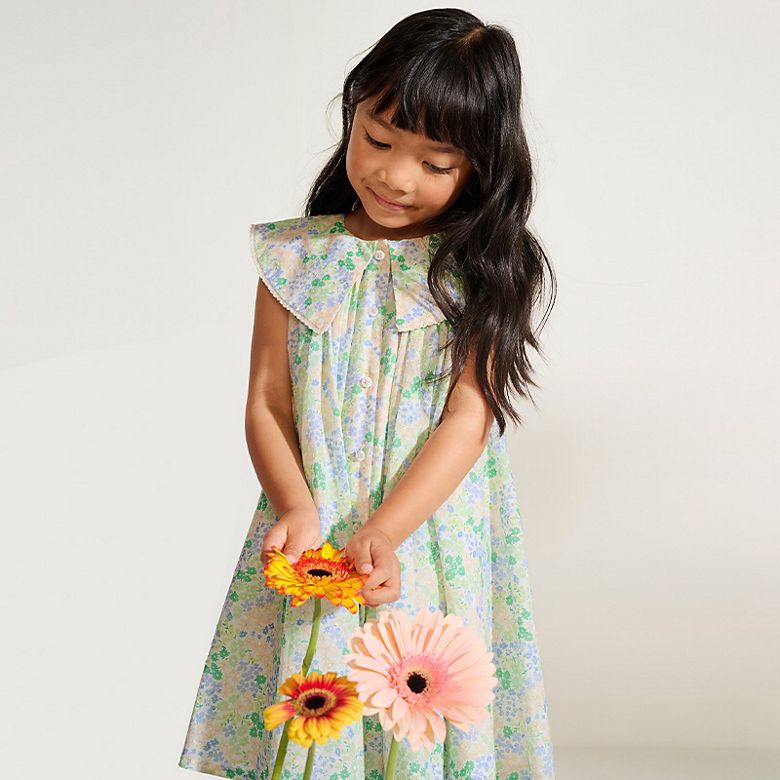 Girl wearing a ditsy floral dress with collar. Shop kids’ new in.