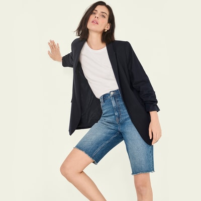 Woman wearing a black blazer and long denim shorts. Shop all blazers 