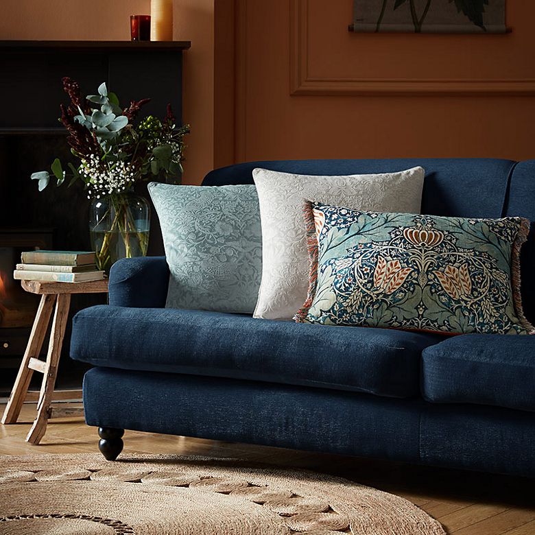 Room with navy blue velvet sofa and William Morris at Home cushions. Shop all home furnishings.