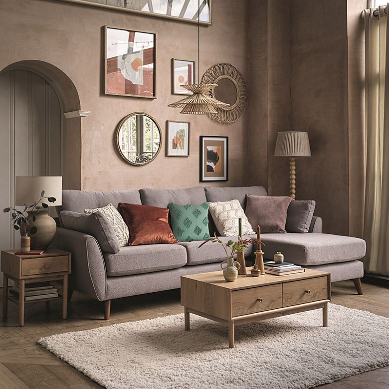 Corner sofa in a living room decorated with cushions. Shop sofas