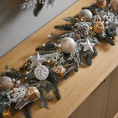 Sideboard decorated with a Cosy Retreat theme. Shop Christmas decorations 