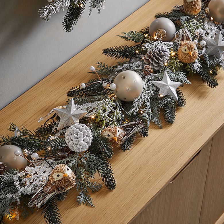 Sideboard decorated with a Cosy Retreat theme. Shop Christmas decorations 