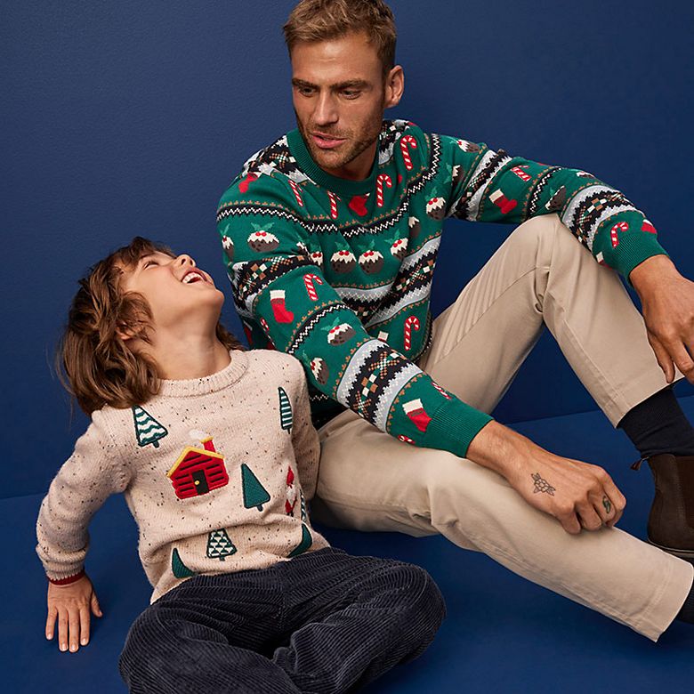 A man and child wearing Christmas jumpers. Shop Christmas jumpers