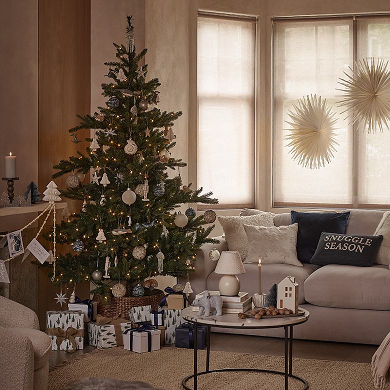 Selection of cream textured cushions in a living room decorated for Christmas. Shop Christmas cushions