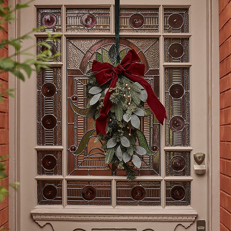 White front door with Christmas wreath. Shop wreaths
