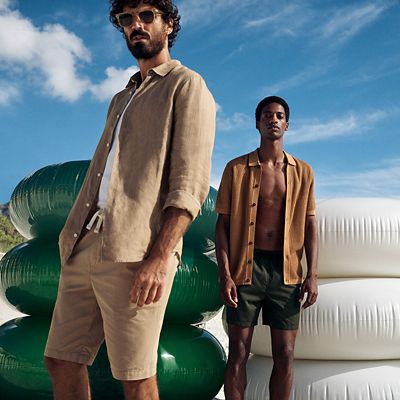 Men wearing linen shirts and shorts at the beach. Shop men’s summer clothing 