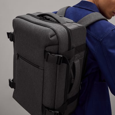 Man carrying a Banff Adventure cabin suitcase as a backpack. Shop suitcases and luggage