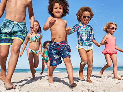 A group of children wearing swimwear on a beach