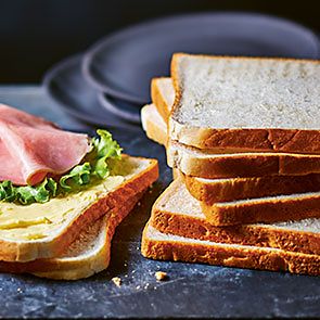 Slices of white bread with ham and lettuce