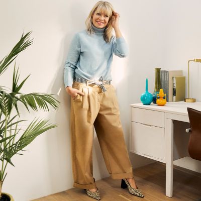 Fran Bacon wearing wide-leg chinos, blue jumper and leopard-print shoes